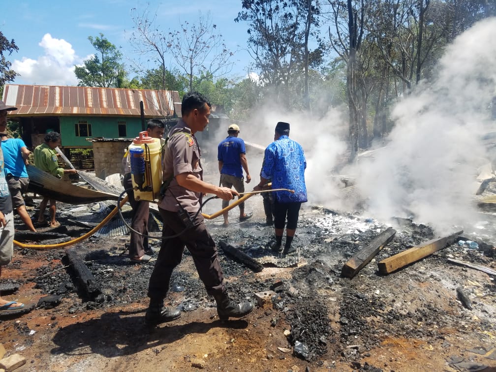 Personel Polsek Tondong Tallasa membantu memadamkan api dengan alat seadanya