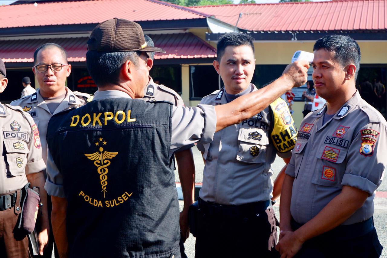 Personel Polres Wajo saat memeriksa suhu tubuh di lapangan apel Mapolres Wajo, Rabu (18/03)