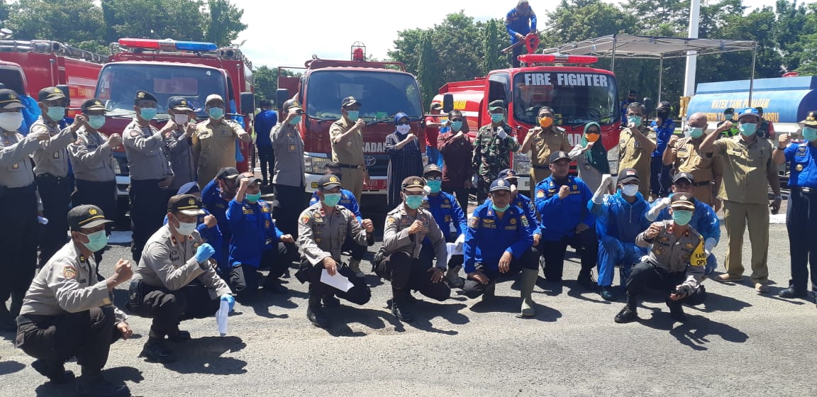 Foto bersama para personel kepolisian dan petugas damkar sebelum turun menyemprot disinfektan ke pemukiman warga, Selasa (31/03)