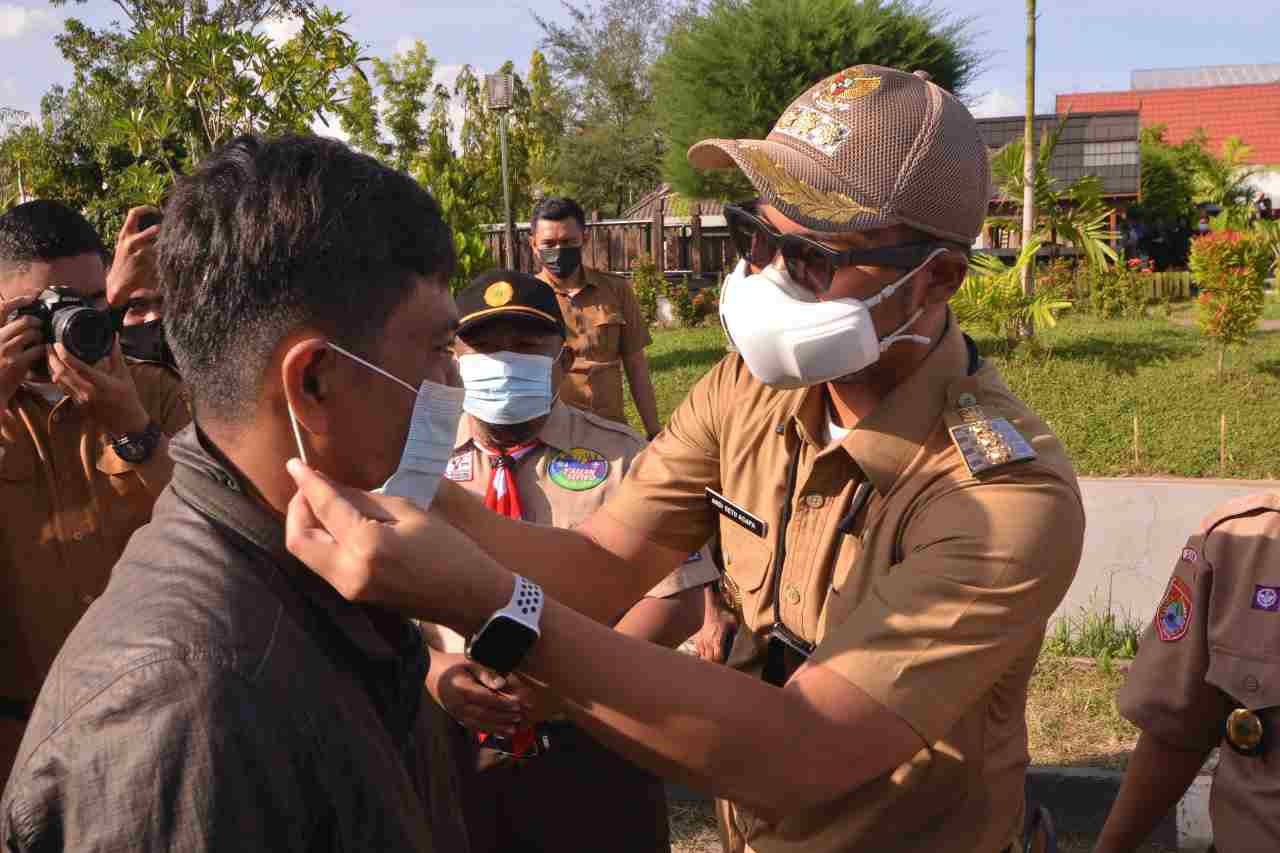 Bupati ASA saat memakaikan warga masker