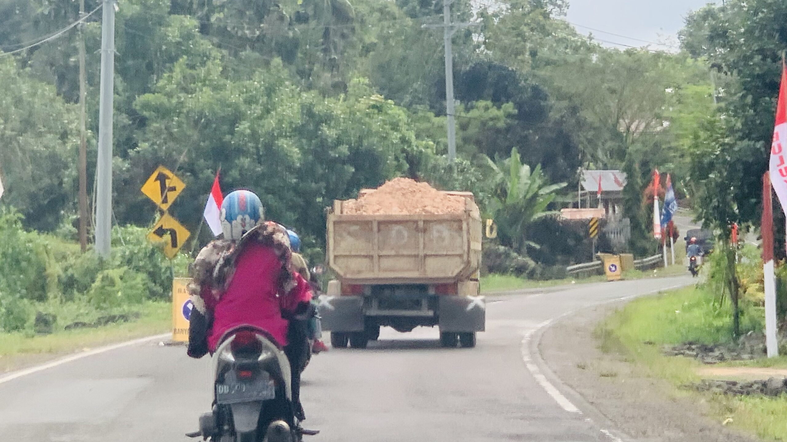 Truk pengangkut material tanpa penutup melintas di Jalan Poros Bulukumba - Sinjai Minggu 14/8/23. (Foto: Heri/BSS)