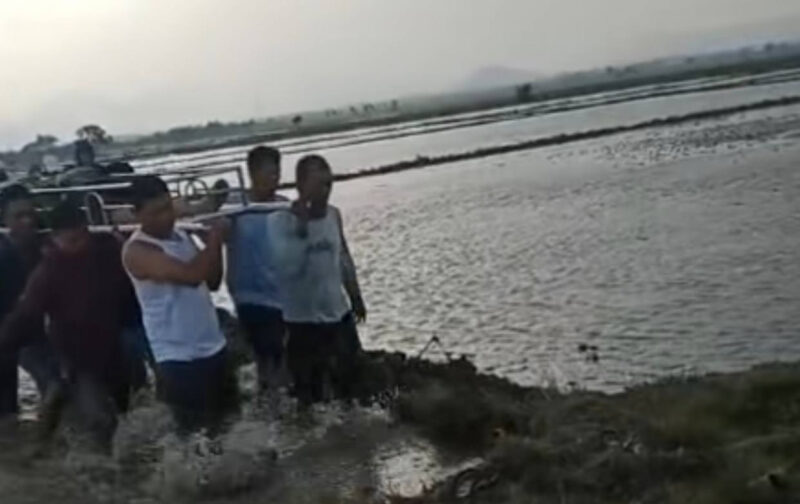 sejumlah warga menandu korban yang tewas disambar petir di tengah sawah