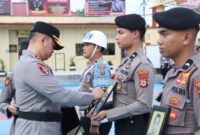 Kapolres Sidrap AKBP Dr. Fantry Taherong menyilang foto dua personel Polres Sidrap yang Dipecat Tidak Dengan Hormat (PTDH) (foto: dok, Humas Polres Sidrap)